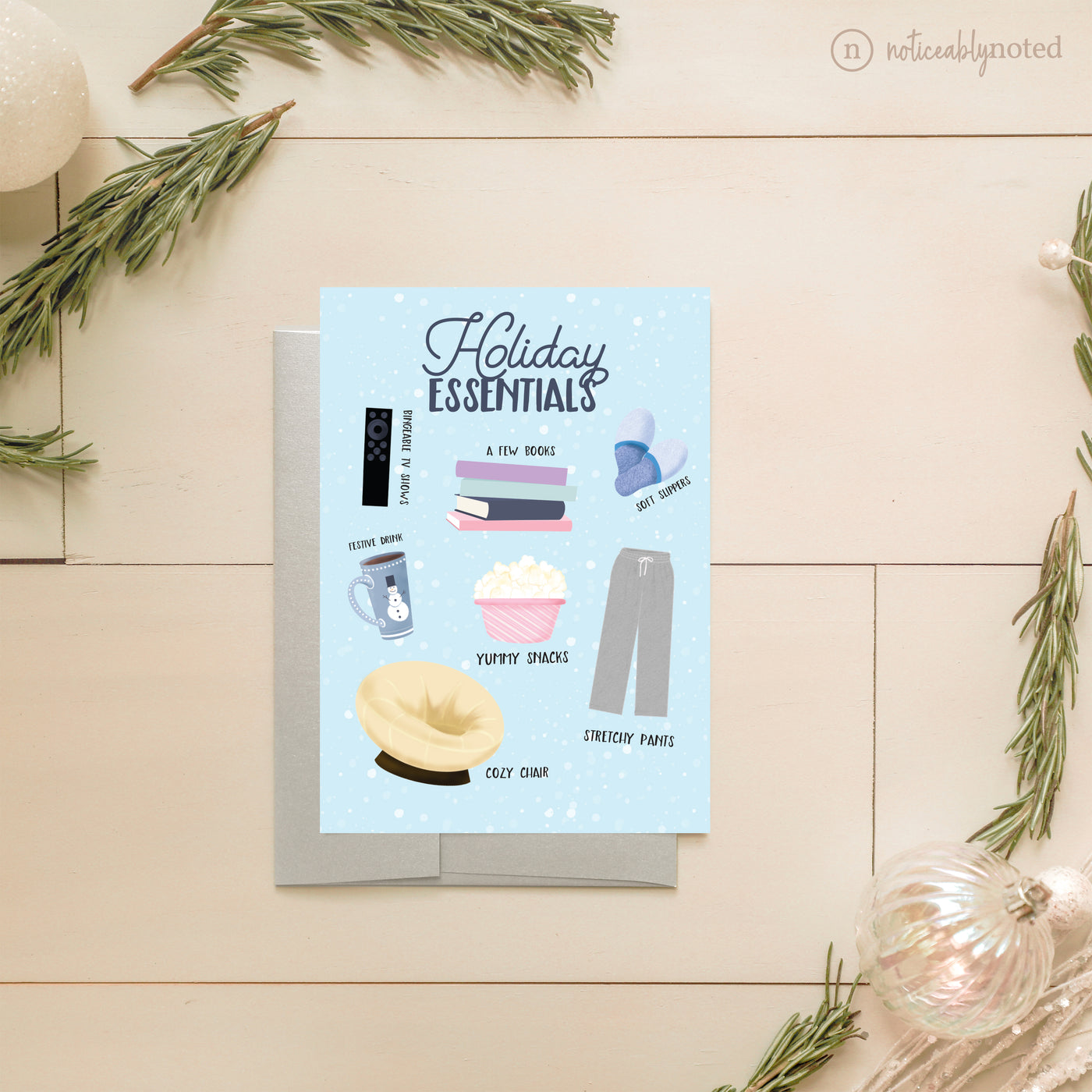 Holiday Essentials Greeting card with illustrations of holiday essentials on a wooden surface