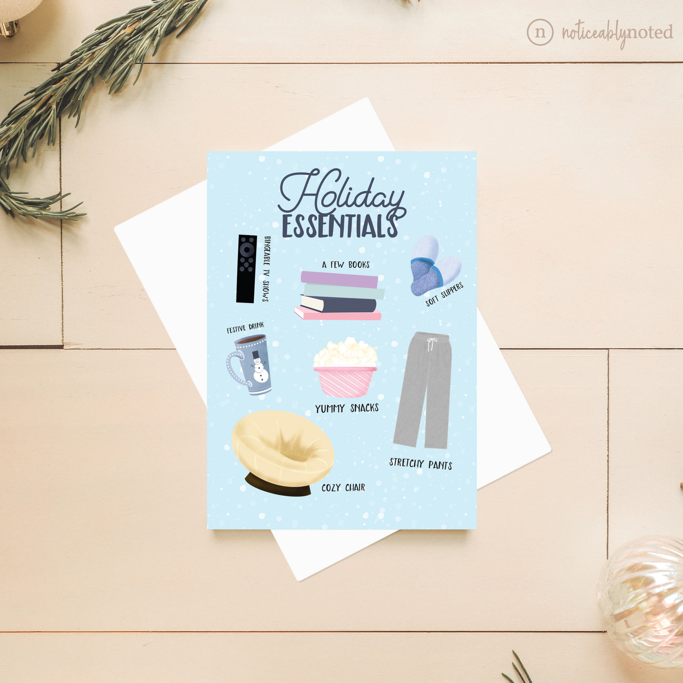 Holiday Essentials Greeting card with illustrations of holiday essentials on a wooden surface