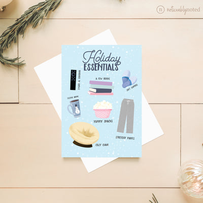 Holiday Essentials Greeting card with illustrations of holiday essentials on a wooden surface