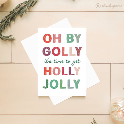 Christmas-themed card with colorful text on a wooden surface
