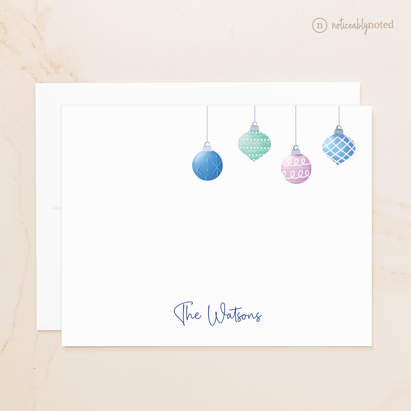 Note card with Christmas ornament design and 'The Watsons' text on a beige background