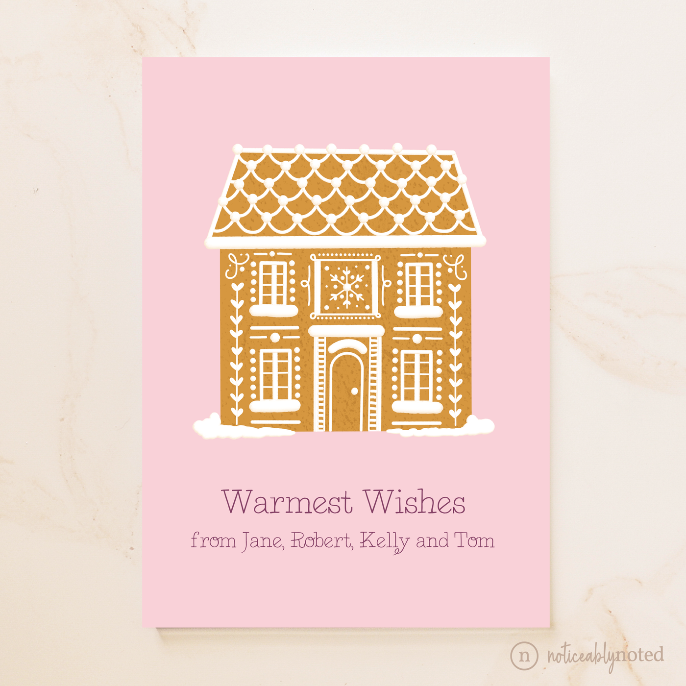 Greeting card with a gingerbread house design on a pink background