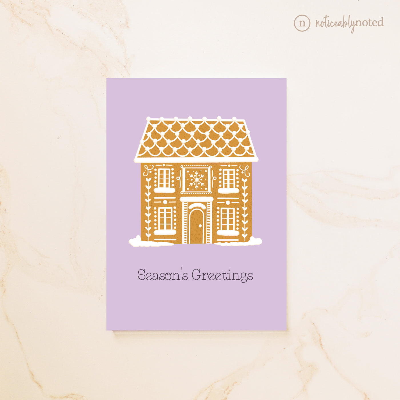 Greeting card with a gingerbread house design on a purple background