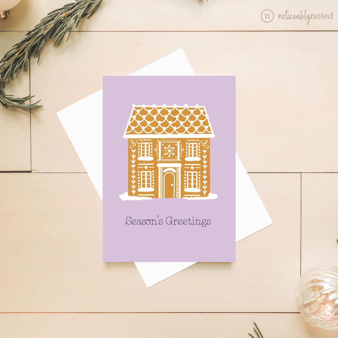 Greeting card with a gingerbread house design on a light wooden surface