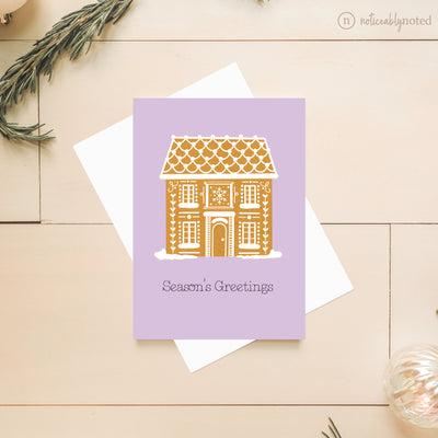 Greeting card with a gingerbread house design on a light wooden surface