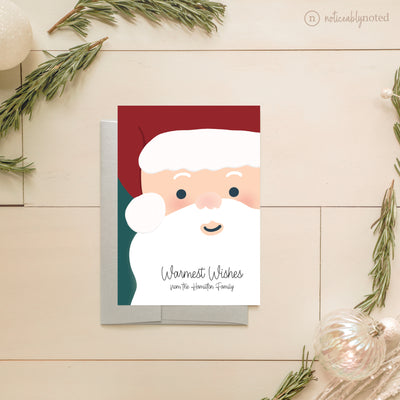 Christmas card with Santa Claus illustration on a wooden surface with decorative elements.