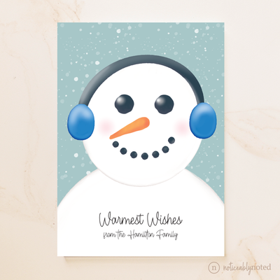 Snowman card with blue earmuffs on a snowy background with 'Warmest Wishes from the Hamilton Family' text.